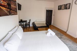 een slaapkamer met een wit bed en een stoel bij Studio Coastal Escape Apartment 2 in Christchurch