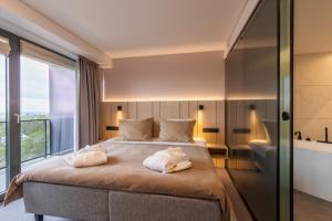 a bedroom with a large bed with two towels on it at Hotel Jurmala Spa in Jūrmala