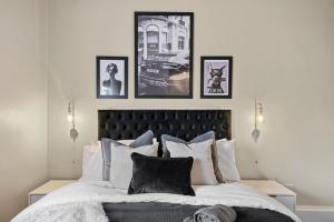 a bedroom with a large bed with four pictures on the wall at Boutique and Stylish Wakefield Apartment in Wakefield
