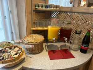 Hotel zur Post في غمبولدسكيرشن: طاولة مع بيتزا وزجاجات عصير برتقال
