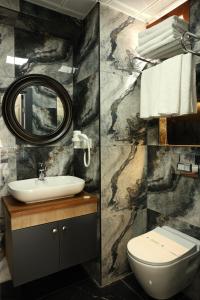 La salle de bains est pourvue d'un lavabo, de toilettes et d'un miroir. dans l'établissement Bizim Hotel, à Istanbul