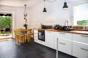 a kitchen with white cabinets and a table with chairs at BELLA VISTA in Cana