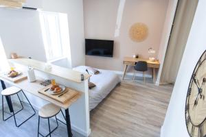 um pequeno quarto com uma cama, uma mesa e cadeiras em Le Refuge Valencien - Douceur et Élégance em Valence-sur-Baïse
