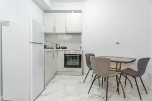 a kitchen with a table and chairs and a refrigerator at Niki's Apartments in Faraí