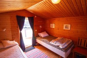 Gopshusgården - Rum & Stugor في مورا: غرفة نوم بسريرين في كابينة خشبية