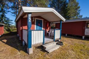 a small red cabin with a porch and a door at Gopshusgården - Rum & Stugor in Mora