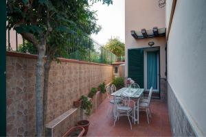 d'une terrasse avec une table et des chaises à côté d'un mur. dans l'établissement Casa Vacanze Il Gatto Rosso, à Trecase