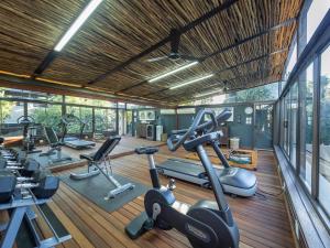a gym with several treadmills and elliptical machines at The Residence in Johannesburg