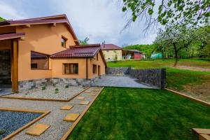 a backyard with a house and a grass yard at Casa Edelweiss in Baia Mare