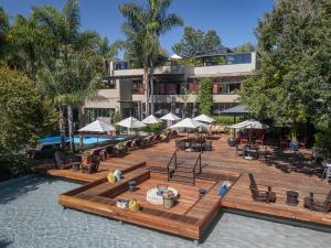 约翰内斯堡住宅酒店的一个带桌子和遮阳伞的游泳池的度假酒店