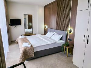a bedroom with a large bed and a mirror at Sonio Boutique Hotel in Mamaia