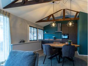 uma cozinha com uma mesa de madeira e paredes azuis em Charming house with garden in rural area Hellendoorn em Hellendoorn