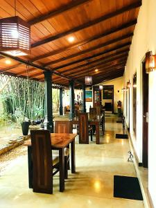 a patio with tables and chairs and a wooden ceiling at The Green Edge in Dambulla