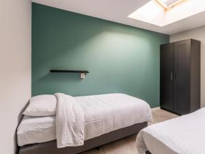 - une chambre avec 2 lits et un mur vert dans l'établissement Charming house with garden in rural area Hellendoorn, à Hellendoorn
