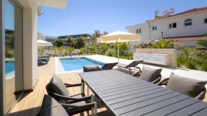 a patio with a table and chairs and a swimming pool at City Napa Seaview Villas - Villa 6 in Ayia Napa