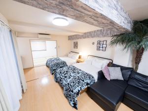 a living room with two beds and a couch at Shinjuku, 1min walk from Kagurazaka Sta ,80square meters,net, PocketWiFi, Switch in Tokyo