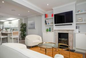 sala de estar con chimenea y TV en GuestReady - Modern Apt in Chelsea with a Terrace, en Londres