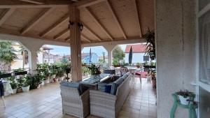 a porch with chairs and tables on a patio at Apartments Gabriela in Poreč