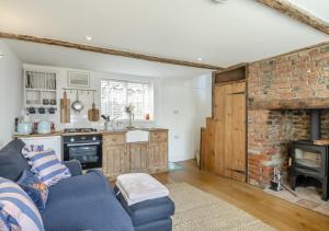 a living room with a blue couch and a kitchen at Fishermans Cottage in Wells next the Sea