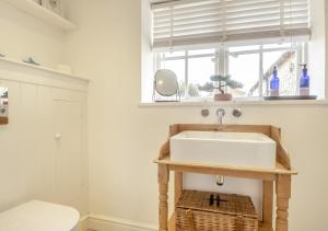 a bathroom with a sink and a window at Fishermans Cottage in Wells next the Sea