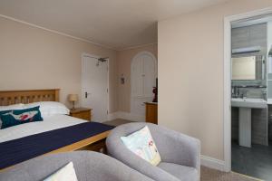 a bedroom with a bed and a chair and a sink at Epchris House in Ilfracombe