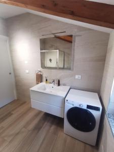 a bathroom with a sink and a washing machine at Casa Marta 11 in Garlenda