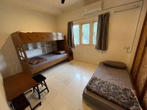 a room with two bunk beds and a desk at House of David - Bungalow at SS2 Petaling Jaya in Petaling Jaya