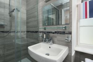 a bathroom with a sink and a glass shower at Epchris House in Ilfracombe