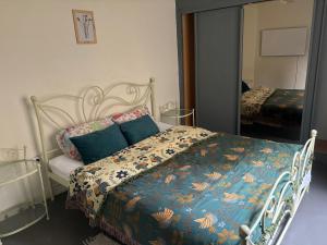 Schlafzimmer mit einem Bett mit blauer Decke und einem Spiegel in der Unterkunft Belle Epoque flat in the heart of Ostend in Ostende