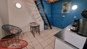 a kitchen with chairs and a staircase in a room at Impasse secrète - Duplex - WIFI in Issoire