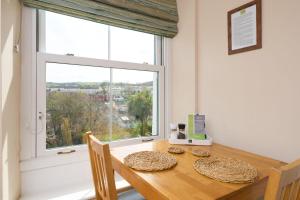 a dining room with a table and a large window at Epchris House in Ilfracombe