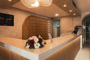 a counter with a bouquet of flowers on it at Adella Side Hotel in Side