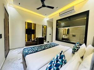 ein Schlafzimmer mit einem großen weißen Bett und einem großen Fenster in der Unterkunft Taj Ronak Luxury Hotels in Agra