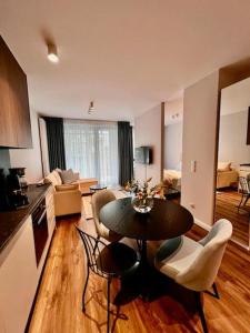 a kitchen and living room with a table and chairs at Scala Apartamenty by Moderna Profit- Łąkowa 60G in Gdańsk