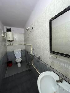 a bathroom with a sink and a toilet and a mirror at Vishwa Deva Homestay in Varanasi