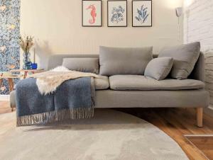 a living room with a couch with a blanket on it at STRELApartment by Meinke mitten in der Altstadt in Stralsund