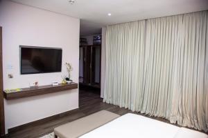 un soggiorno con TV e divano di The White Orchid Hotel a Lagos