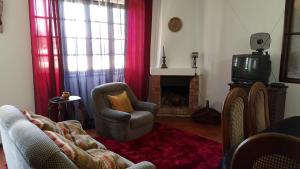 a living room with a couch and a tv and a chair at Quinta da Lage in Barcelos