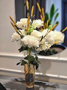 un jarrón lleno de flores blancas en una mesa en Milestone SaiGon, en Ho Chi Minh