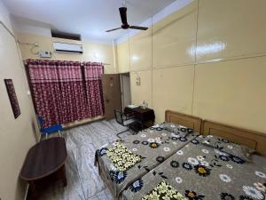 瓦拉納西的住宿－Vishwa Deva Homestay，一间卧室配有一张床和吊扇