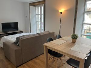 een woonkamer met een bank en een tafel bij Apartamento con encanto in Santiago de Compostela