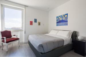 sypialnia z łóżkiem, krzesłem i oknem w obiekcie Napolidays Toledo Apartment By Dimorra w mieście Neapol
