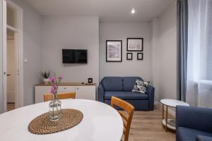 a living room with a table and a blue chair at 29 Gdynia Centrum - Apartament Mieszkanie dla 4 os in Gdynia
