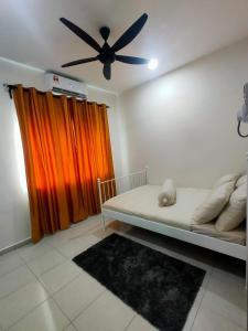 een slaapkamer met een bed en een plafondventilator bij Swedish Style Homestay in Teluk Intan