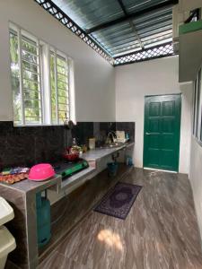 a kitchen with a green door and a counter at Swedish Style Homestay in Teluk Intan