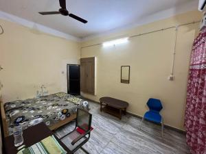 a bedroom with a bed and a blue chair at Vishwa Deva Homestay in Varanasi