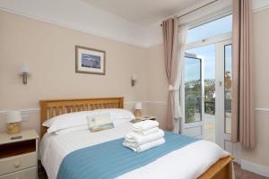 a bedroom with a bed with towels on it at Epchris House in Ilfracombe