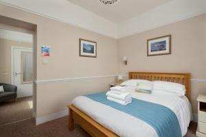 a bedroom with a bed with towels on it at Epchris House in Ilfracombe
