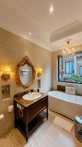 a bathroom with a tub and a sink and a mirror at Dandaman villa in Yogyakarta