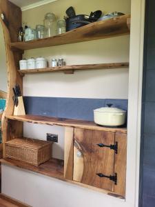 um armário de cozinha com prateleiras de madeira e um lavatório em Courtlands farm camping and glamping em Canterbury